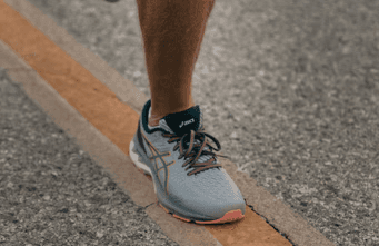 Close-up of a running shoe on a painted road line