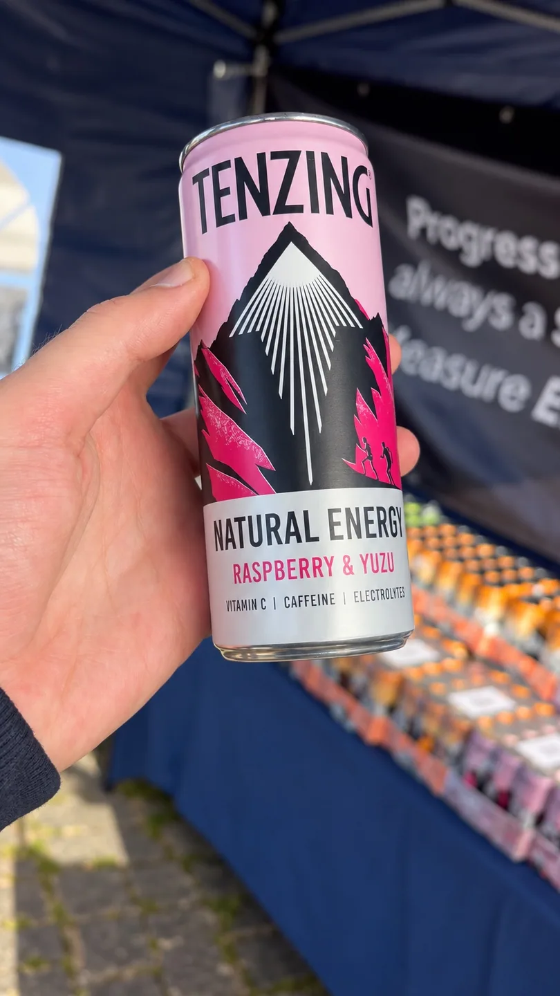 A TENZING Raspberry & Yuzu can held in front of the MOTRA event stand.